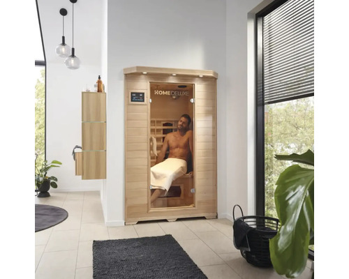 Interiérový záber kúpeľne so saunou Home Deluxe a mužom s uterákom