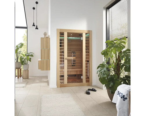 Svetlá miestnosť so saunou Home Deluxe, rastlinami a kúpeľňovým nábytkom.