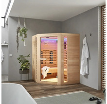 Rohová drevená infra sauna v kúpeľni s vaňou, uterákmi a rastlinami.