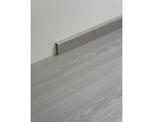 Podlahová lišta imitujúca drevo namontovaná na stene