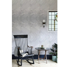 Obývacia izba s mramorovou tapetou, hojdacím kreslom, odkladacím stolíkom a rastlinami