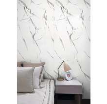 Spálňa s nástennými panelmi so vzhľadom mramoru, posteľou a nočným stolíkom