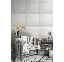 Svetlá obývacia izba s mramorovými obkladmi, kreslom a dekoráciami pre štýlovú atmosféru.