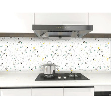 Kuchynská scéna s dlaždicami so škvrnitým vzorom, sporákom a odsávačom pár.