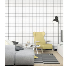 Obývacia izba s pohovkou, kreslom, lampou, stolom a tapetou so štvorcovým vzorom