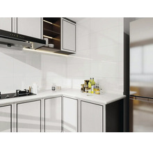 Svetlá kuchyňa s bielymi obkladmi, kuchynskými skrinkami a digestorom