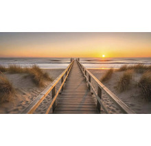 Drevená lávka na pláži pri západe slnka