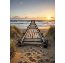 Drevená lávka vedúca na pláž a k moru pri západe slnka.