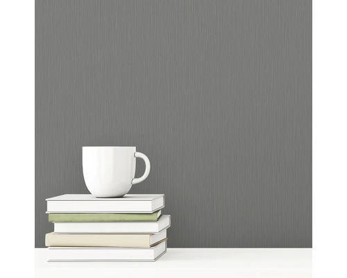 Sivá vliesová tapeta s textilnou štruktúrou vedľa šálky a kníh