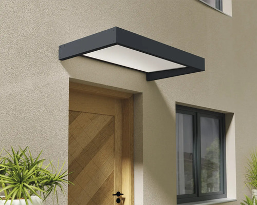 Moderná vchodová strieška v antracitovej farbe s bielou výplňou inštalovaná nad drevenými vchodovými dverami na omietnutej stene.