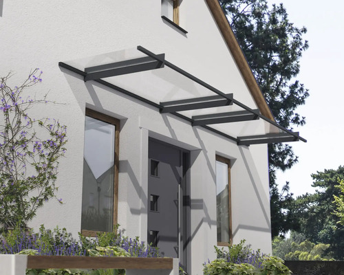 Moderná sklenená strieška s tmavým kovovým rámom nad vchodovými dverami na svetlej fasáde.