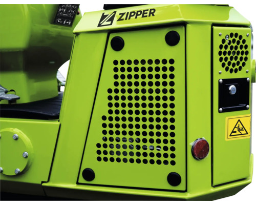 Detailný pohľad na pracovný stroj Zipper s vetracími mriežkami a varovaním