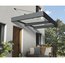 Moderná vchodová strieška s tmavým hliníkovým rámom a priesvitnými panelmi, namontovaná na svetlej stene domu nad drevenými dverami.