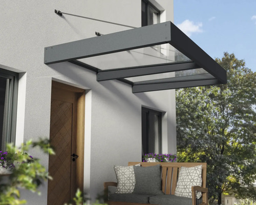 Moderná vchodová strieška s tmavým hliníkovým rámom a priesvitnými panelmi, namontovaná na svetlej stene domu nad drevenými dverami.