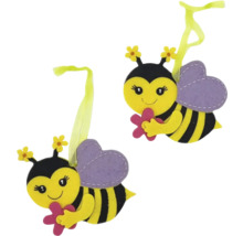 Dva dekoratívne včelie prívesky s kvetmi v rukách a slučkami na zavesenie.