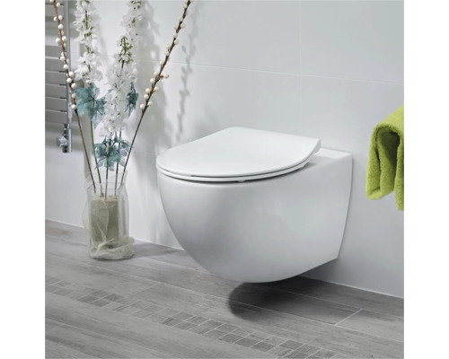 Závesné WC s WC sedátkom v svetlej kúpeľni.