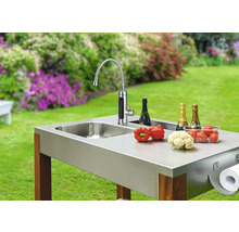 Vonkajšia kuchyňa s drezom, batériou, zeleninou, šampanským a držiakom papierových utierok v záhrade