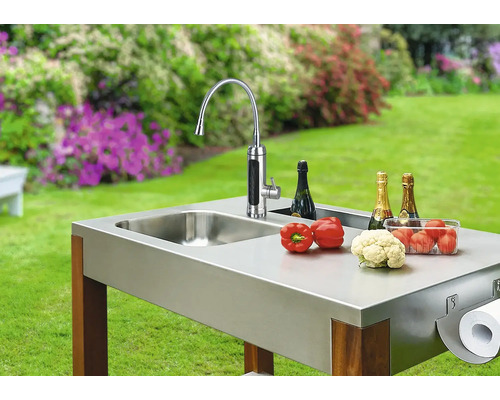 Vonkajšia kuchyňa s drezom, batériou, zeleninou, šampanským a držiakom papierových utierok v záhrade