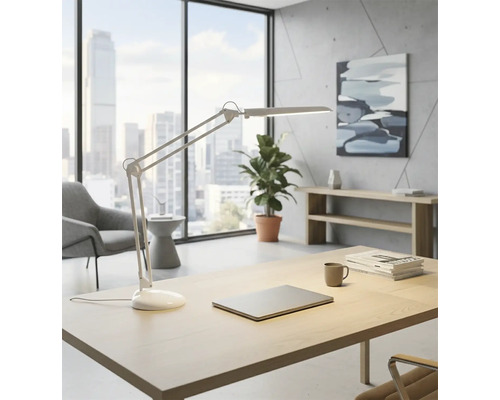 Svetlá kancelária s písacím stolom, stolnou lampou, notebookom, rastlinou a oknom s výhľadom na mesto