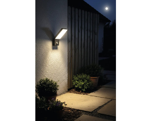 Moderné LED vonkajšie svietidlo s pohybovým senzorom na stene domu v noci