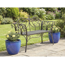 Ozdobná kovová záhradná lavička s kvetináčmi na záhradnej terase