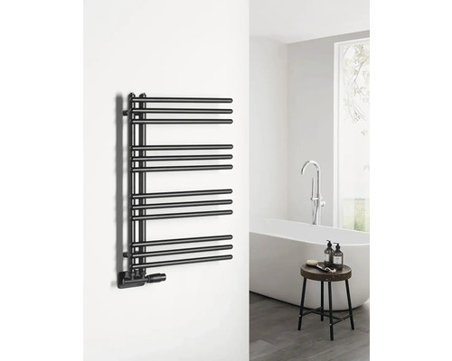 Čierny radiátor na uteráky v kúpeľni s vaňou a stoličkou