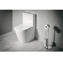 Stojace WC kombi z keramiky s nádržkou a sedadlom vedľa chrómovaného stojana na toaletný papier a WC kefy v kúpeľni.