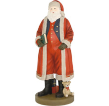 Figúrka Santa Clausa v červenom kabáte s kožušinou, drží zelenú knihu, vedľa neho medvedík a darčeky na okrúhlom podstavci.