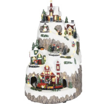 LED osvetlená miniatúrna vianočná dedinka na hore s domami, kostolom, idúcim vlakom a zimnými postavičkami.