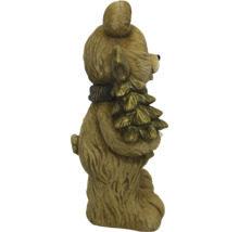Vianočná figúrka medveď so šálom drží vianočný stromček.