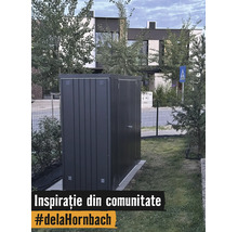 Moderný kovový záhradný domček v tmavosivej farbe na trávniku v záhrade pred domom.