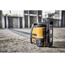 Krížový laser DeWalt na betónovej podlahe v novostavbe pre presné vyrovnanie.