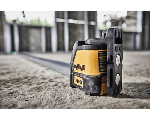 Krížový laser DeWalt na betónovej podlahe v novostavbe pre presné vyrovnanie.