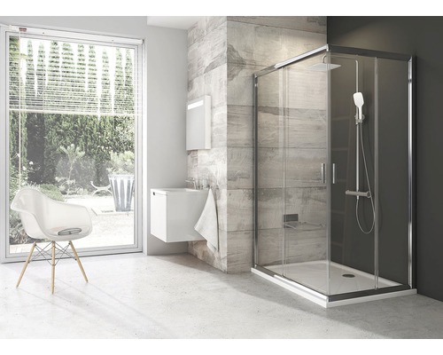 Moderná kúpeľňa so sprchovacím kútom, umývadlom a stoličkou v svetlej izbe.