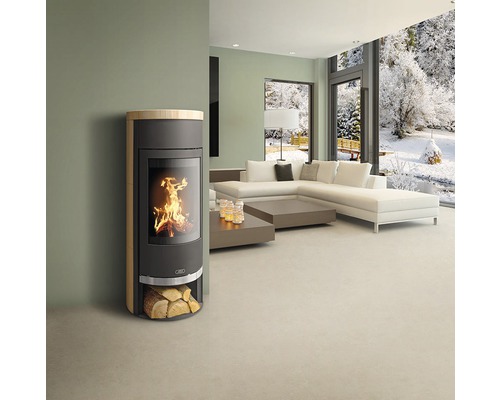 Obývacia izba s krbovými kachľami, pohovkou a výhľadom na zasneženú krajinu