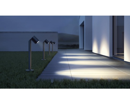 Rad záhradných svietidiel vedľa cesty na trávniku