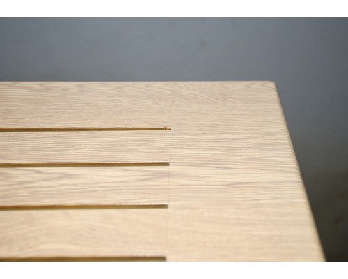 Detailný pohľad na dosku stola s drevenou štruktúrou a úzkymi výrezmi