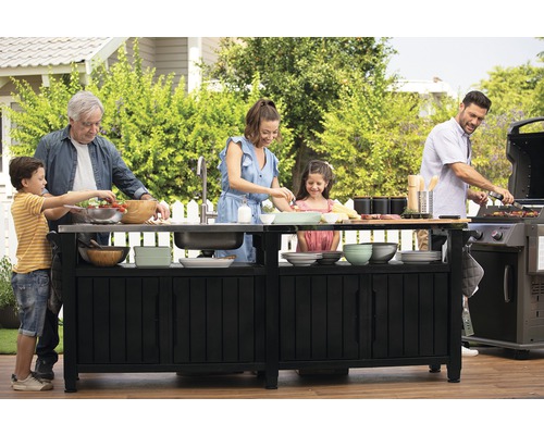 Rodina pripravuje jedlo na grilovacom ostrovčeku v záhrade