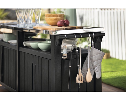 Čierna vonkajšia kuchyňa s kuchynským náčiním, riadom a doskou na krájanie