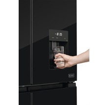 Čierna chladnička s dávkovačom vody a osobou plniacej pohár vody.