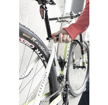 Detailný záber na bicykel, ktorého sedlovka je nastavovaná nástrojom.