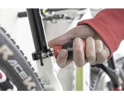 Muž používa skrutkovač Wiha na bicykli.