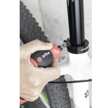 Osoba upevňuje sedlovku bicykla skrutkovačom Wiha.