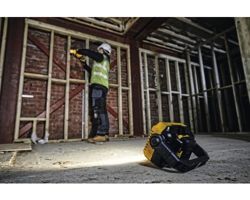 Stavenisko s robotníkom pracujúcim s akumulátorovou lampou