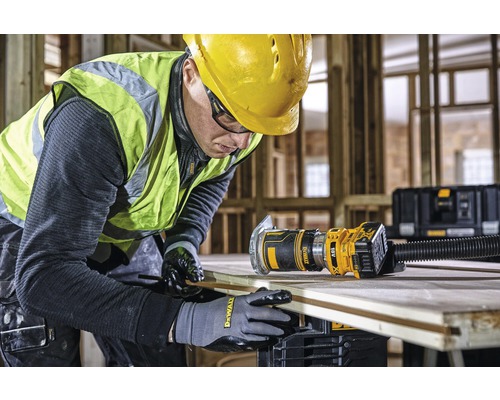 Remeselník pracuje s hornou frézou DeWalt na drevenej doske