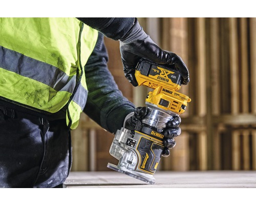 Osoba pripevňuje batériu k hornej frézke Dewalt