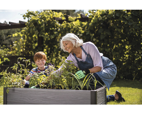 Žena a dieťa pracujú na záhradnom záhone.