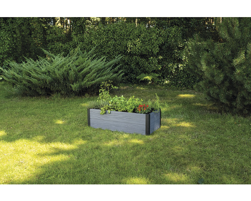 Vyvýšený záhon z drevoplastu s rastlinami v záhrade