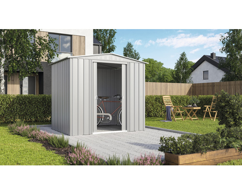 Záhradná scéna s kovovým záhradným domčekom a bicyklom vnútri.