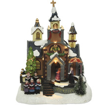 Osvetlený vianočný kostol s postavami zboru ako dekorácia